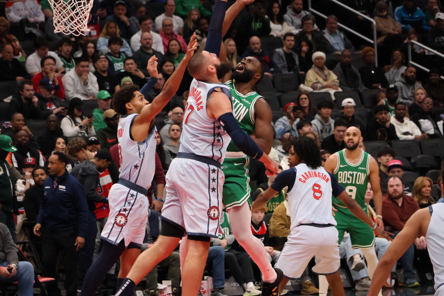 Jonas Valančiūnas challenges Jaylen Brown at the rim during a Washington Wizards game against Boston in December 2024