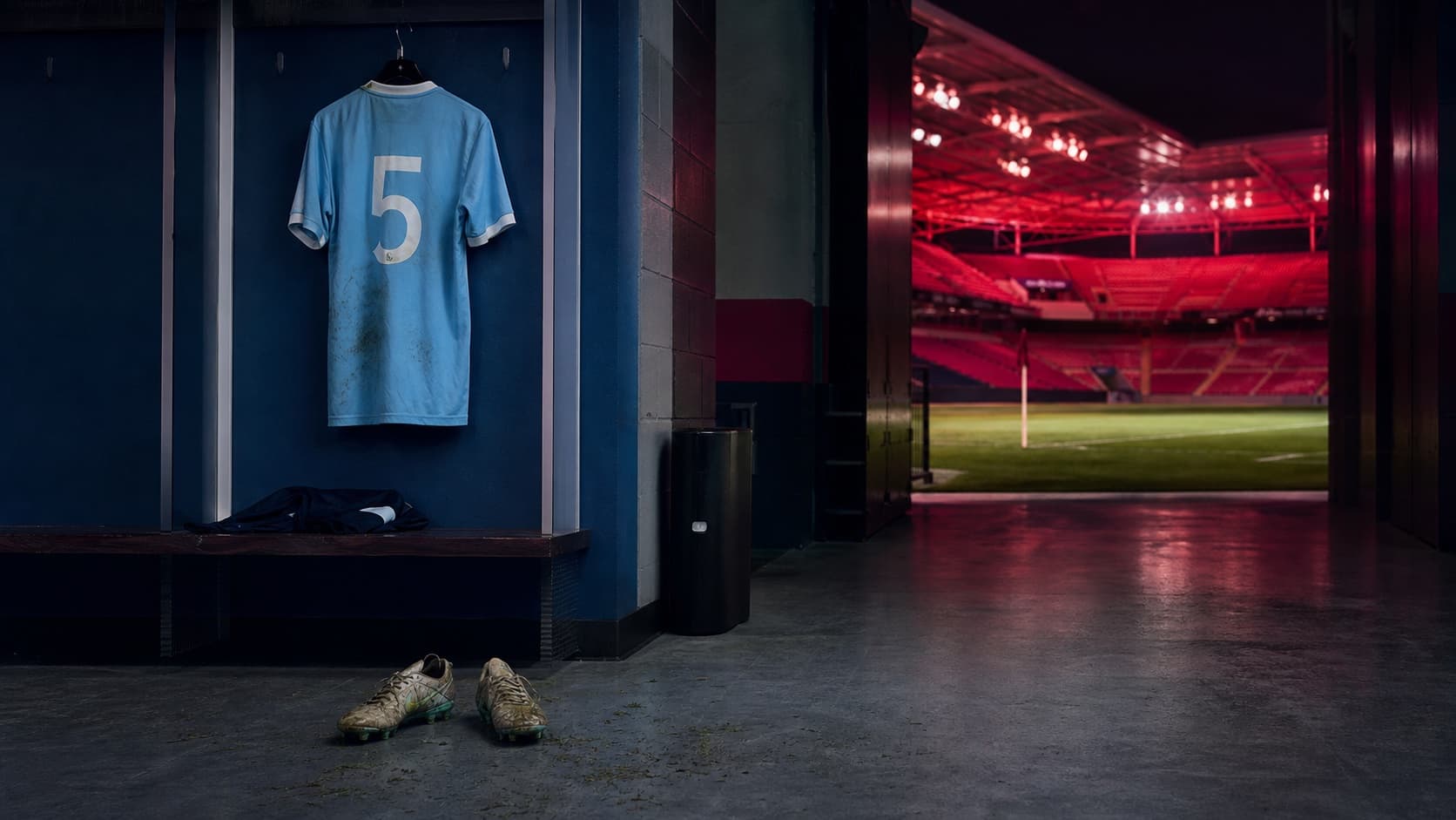 A sky-blue number 5 football shirt hangs in the away dressing room beside a tunnel glowing in St. Louis colours