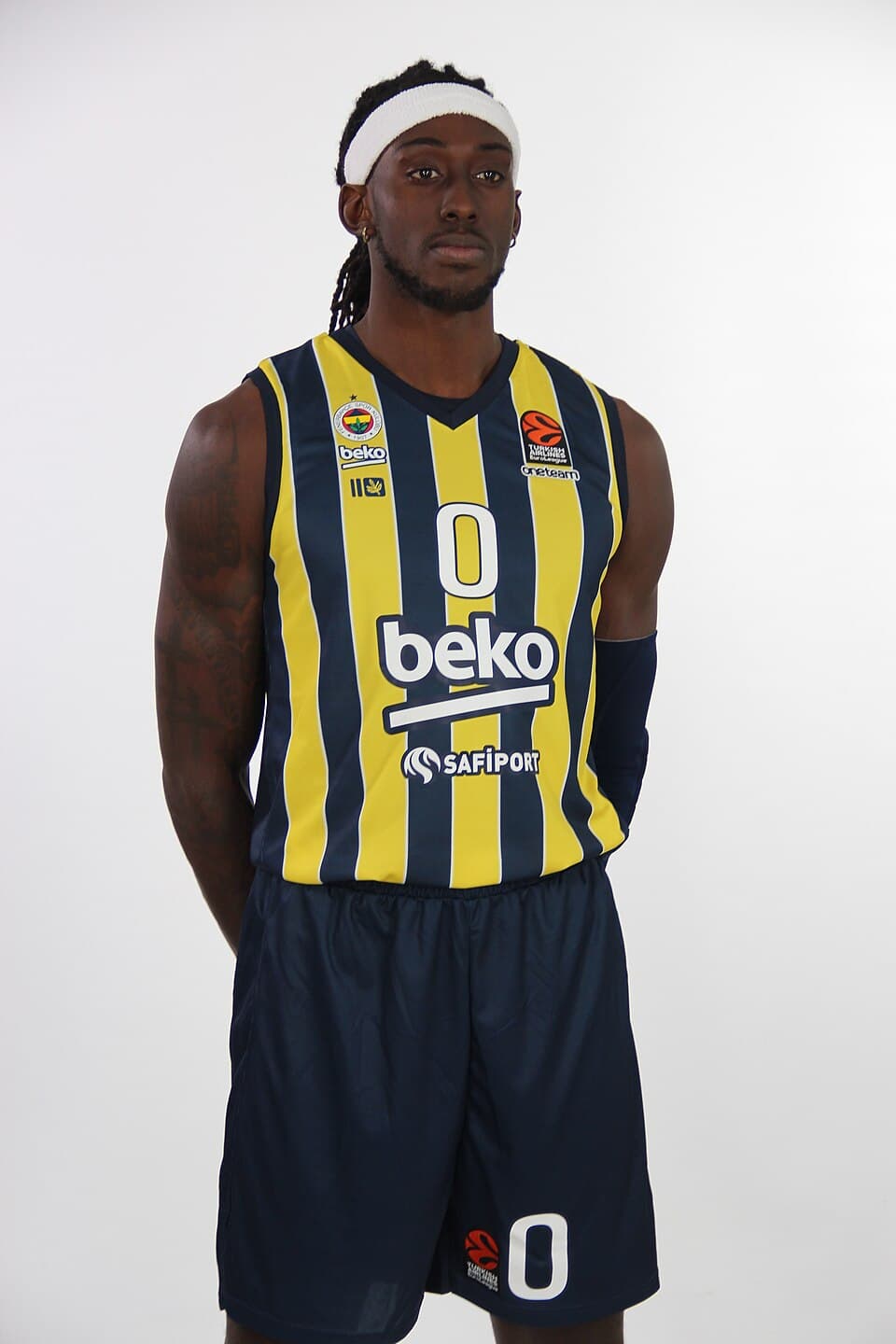 Johnathan Motley poses in Fenerbahçe's yellow-and-navy basketball kit