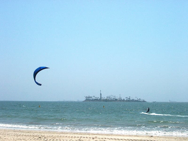 A kiteboarder races in strong wind on Alamitos Bay beside Belmont Shore in Long Beach